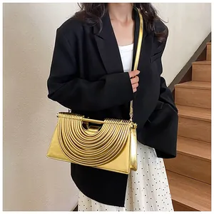 Detail of layered gold metallic crossbody bag with structured semi-circular arc design