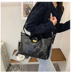 Close-up of a black quilted leather tote bag with a golden square twist lock for daily use