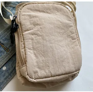 Nahaufnahme der beigen wasserdichten Nylon-Umhängetasche mit Doppelreißverschluss
