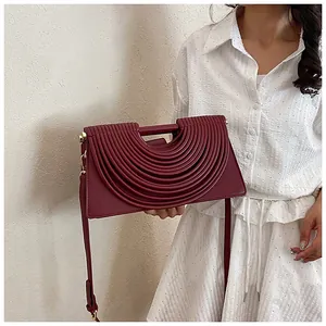 Close-up of wine red rectangular crossbody bag with artistic layered rib pleats details