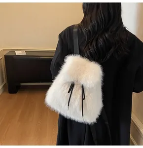 Detail of white plush faux fur backpack with black drawstring accents on model back