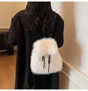 Detail of soft white faux fur backpack featuring contrasting black drawstrings on the flap