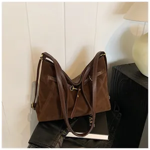 Close-up of vintage brown suede tote bag with leather straps and gold metal buckles