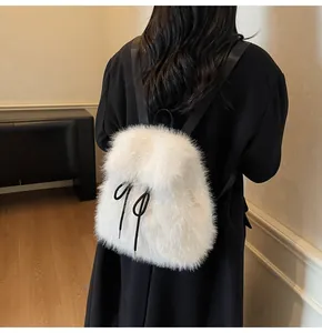 Close-up of white plush backpack featuring black drawstring bow and soft fur texture
