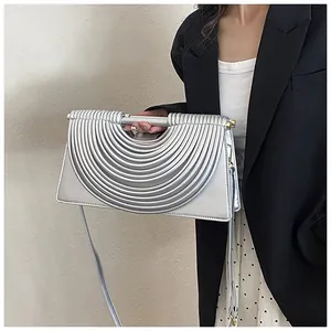 Close-up of metallic silver woven bag with pleated design and cylindrical handle