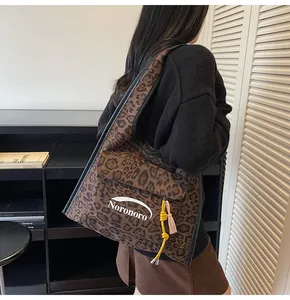 Detail of leopard print canvas tote bag with yellow tassel and Noronoro logo branding