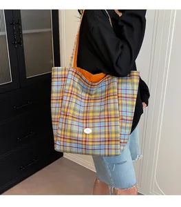 Detailed back view of a large plaid tote bag worn by a model in a minimalist home setting