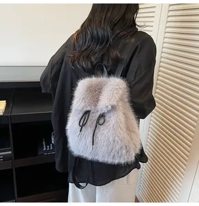 Detailed view of light gray plush faux fur backpack with black straps and soft texture