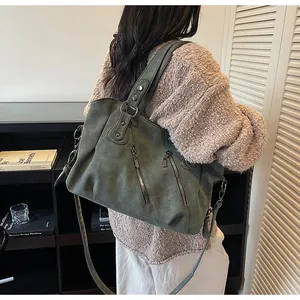 Détail d'un grand sac cabas vert olive avec poches zippées et garnitures métalliques
