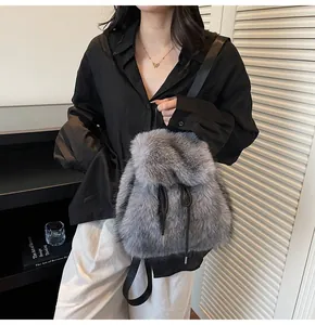 Detail view of plush grey faux fur backpack with black drawstring and adjustable straps