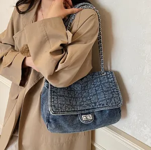 Sac bandoulière en denim délavé bleu foncé avec motif matelassé et chaîne métal