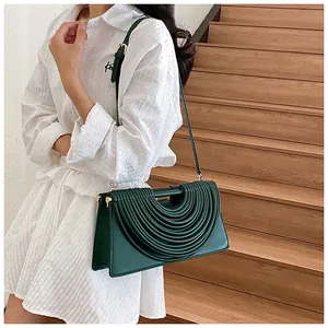 Detail of dark green woven leather handbag with multi-layer curved ripple texture and gold buckle