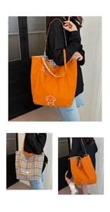 Close-up of reversible tote bag showing orange dog print and blue-yellow plaid pattern