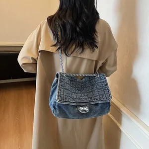 Sac à bandoulière en denim bleu matelassé avec chaîne argentée et fermoir en métal