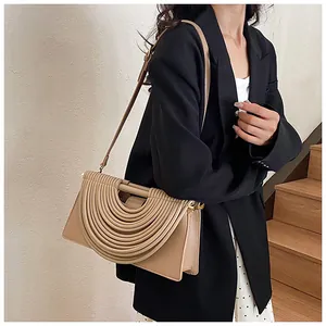 Detail of khaki leather shoulder bag featuring unique semi-circular pleated design