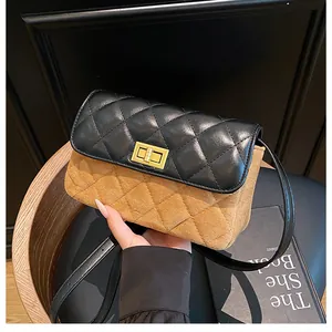 Detail of suede crossbody bag with black quilted flap and golden metal clasp closure