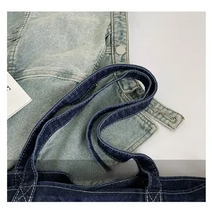 Close-up of reinforced denim tote bag handles with white contrast stitching detail