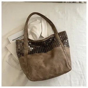 Λεπτομέρεια vintage καφέ τσάντα tote με μεταλλικά τρουκς και ματ υφή δέρματος