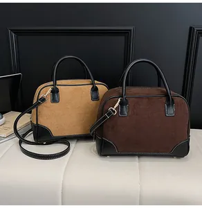 Λεπτομέρεια από vintage σουέτ τσάντες Boston με ραφές αντίθεσης και δερμάτινες λαβές