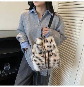 Detail of plush leopard print bucket bag with black slim straps and drawstring closure