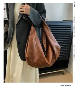 Detailed view of the brown large-capacity tote bag in textured PU leather on a model