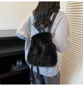 Detail of a fluffy black faux fur backpack with drawstring closure shown on model