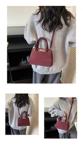 Dettaglio borsa tote bordeaux in finta pelle scamosciata con chiusura dorata e tracolla