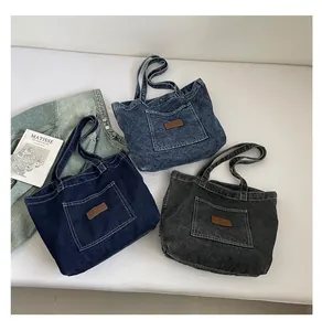 Detailed flat lay of denim tote bags in dark blue, light blue, and charcoal grey tones
