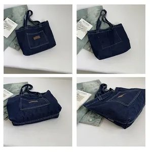 Detail view of large denim tote bag featuring external pocket and woven brand label