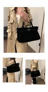 Κοντινό πλάνο μαύρης σουέτ τσάντας tote με ασημένια αγκράφα και κομψή βελούδινη υφή