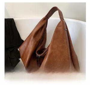 Detail view of large dark brown tote bag with vintage texture and zipper closure