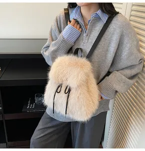 Detail of beige faux fur backpack showing soft texture and black drawstring closure