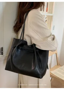 Close-up of black textured large tote bag with elegant drawstring and knot detail