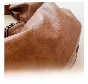 Detail of dark brown lychee grain leather tote bag with silver metal zipper and neat stitching