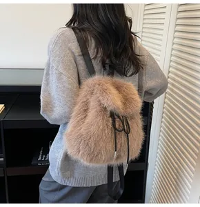 Close-up of fluffy light brown faux fur backpack with black drawstring closure and soft texture