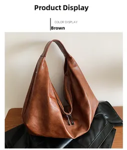 Close-up of brown PU leather tote bag with grainy texture and dual metal zippers