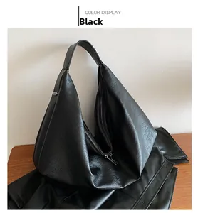 Close-up of black leather tote bag featuring litchi texture and metal buckle detail