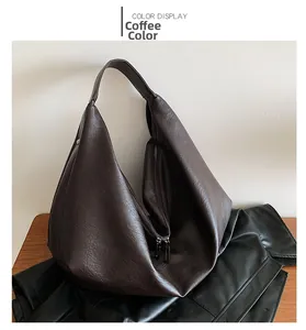 Detail view of large coffee brown leather tote bag with lychee texture and dual zippers
