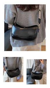 Detail of black crescent moon bag with vintage geometric pattern wide shoulder strap