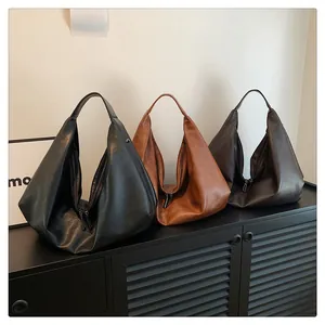 Detailed close-up of three textured PU leather hobo bags in black, brown and dark coffee