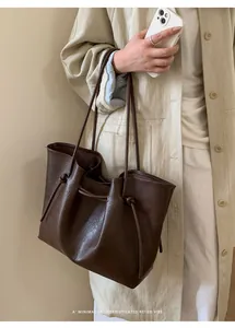 Detailed side view of deep brown vintage tote bag featuring litchi grain texture