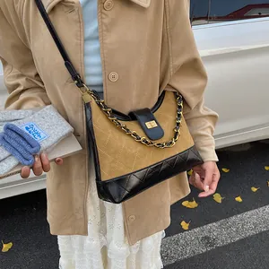 Κοντινό πλάνο καπιτονέ τσάντας από χακί σουέτ και μαύρο δέρμα με χρυσή μεταλλική κλειδαριά