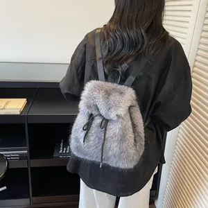 Grey faux fur backpack with drawstring closure and adjustable straps for winter fashion