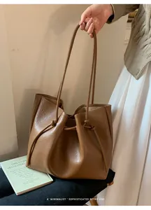 Detail of retro brown tote bag featuring drawstring closure and stylish knotted shoulder strap
