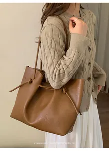 Detail of caramel leather tote bag with elegant knot strap and retro minimalist texture