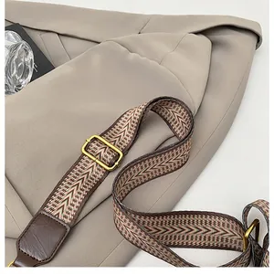 Close-up of ethnic chevron patterned wide shoulder strap with golden metal buckle