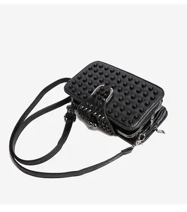 Detail view of black punk style crossbody bag with studded rivets and layered zippers