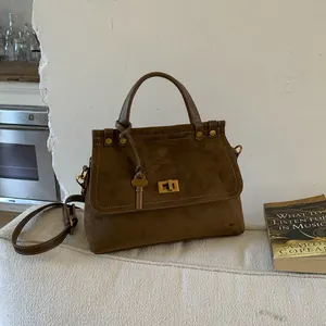 Vintage dark brown suede Kelly bag with gold hardware and top handle for autumn style