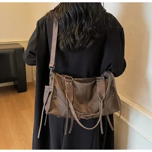 Close-up of vintage dark brown tote bag featuring decorative long tassels and metal buckles