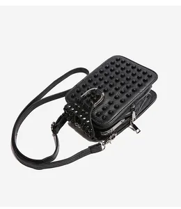 Close-up of black studded crossbody bag with silver hardware and multi-layer compartments
